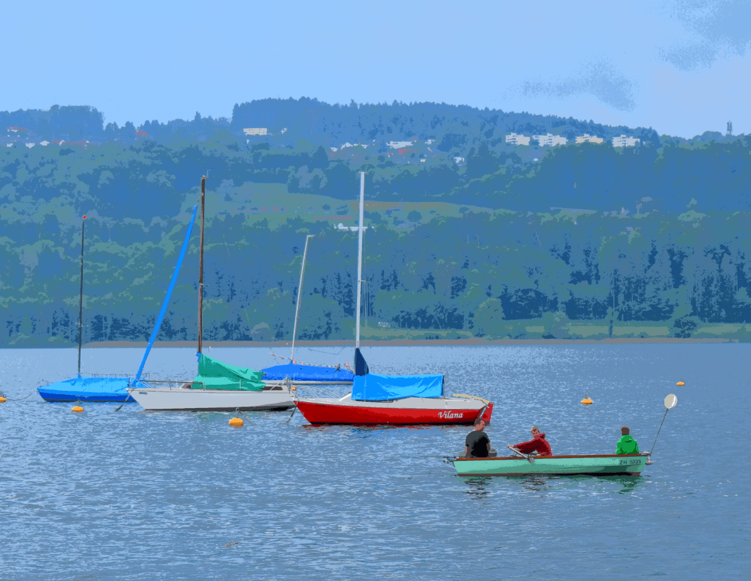 Three people in a small rowboat, several sailboats in background