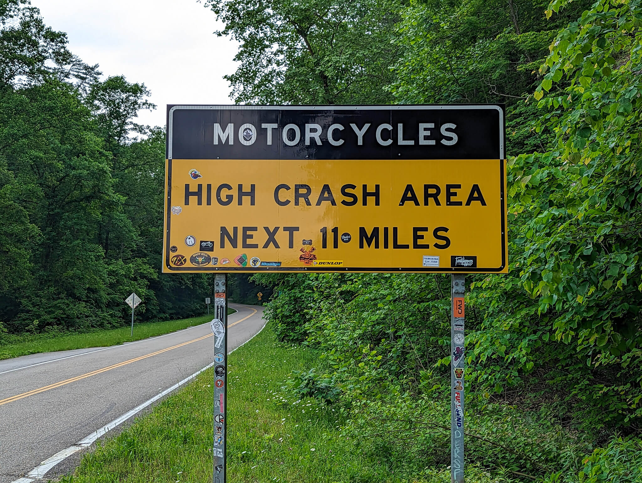 Sign reading “Motorcycles: High Crash Area Next 11 Miles”