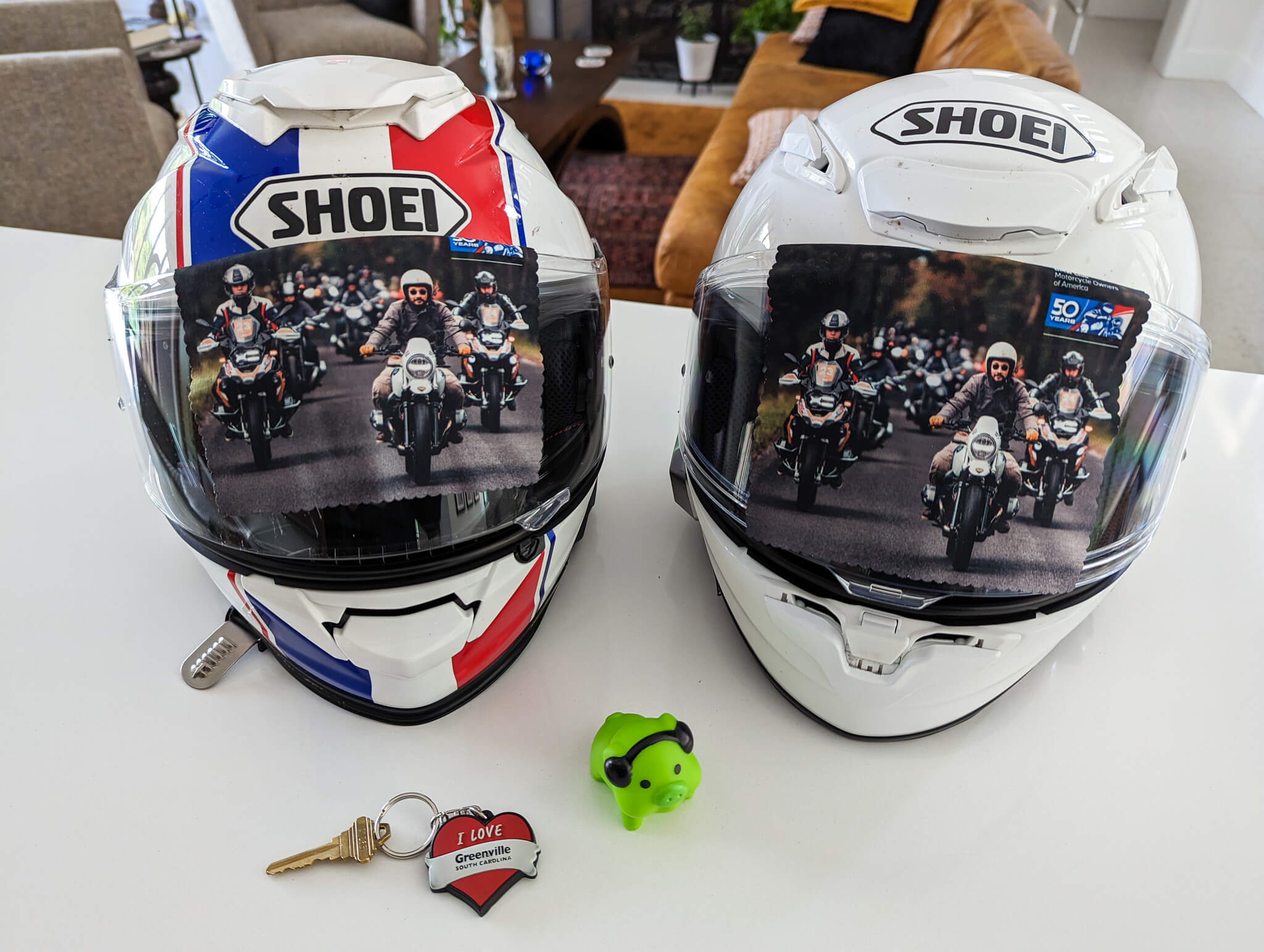 Pair of SHOEI motorcyle helments with images of cyclists on their visors