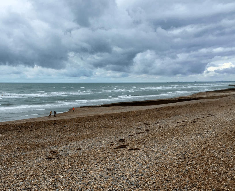 A rocky beach on the ocean under a cloudy sky
