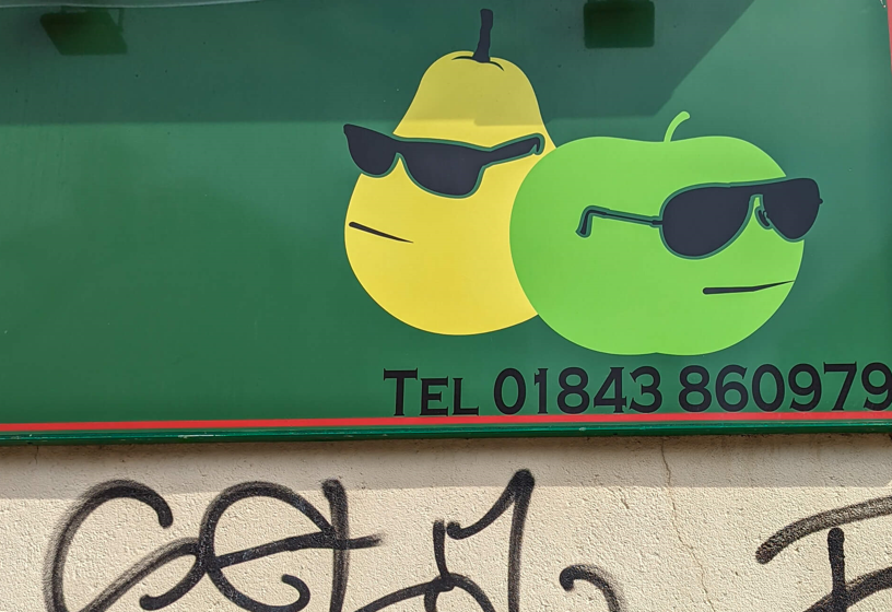 Mural of pear and apple wearing sunglasses above grafitti