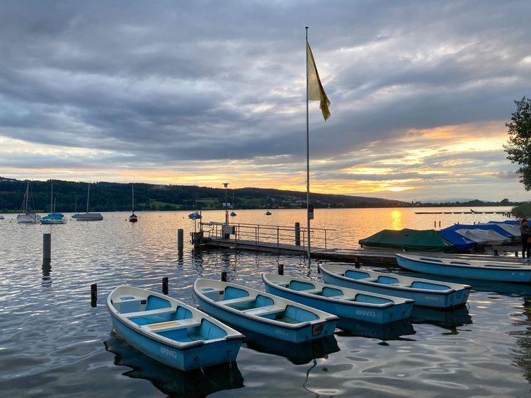 Lake at twilight with small blue and white rowboats in foreground