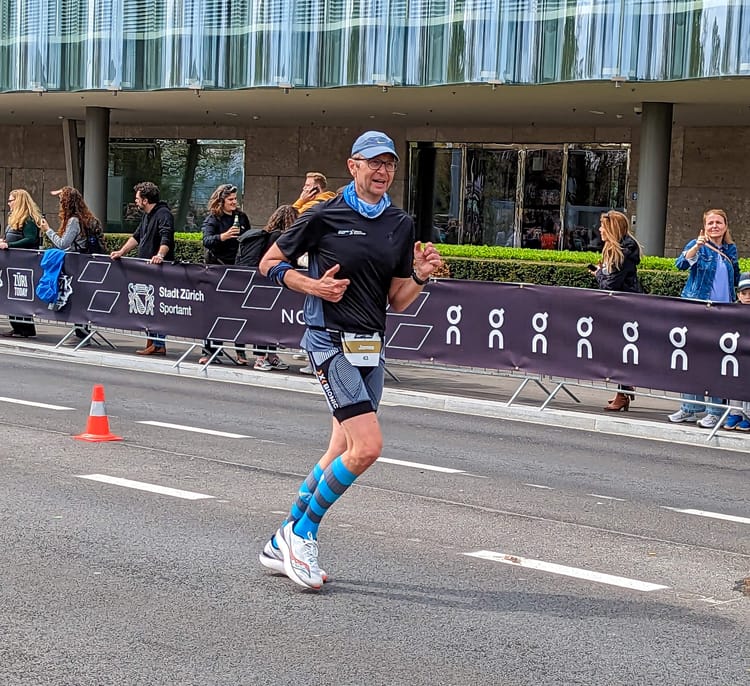 A runner in shorts and t-shirt with striped socks near the finish of a race. On my way to finishing my 20th Zurich marathon