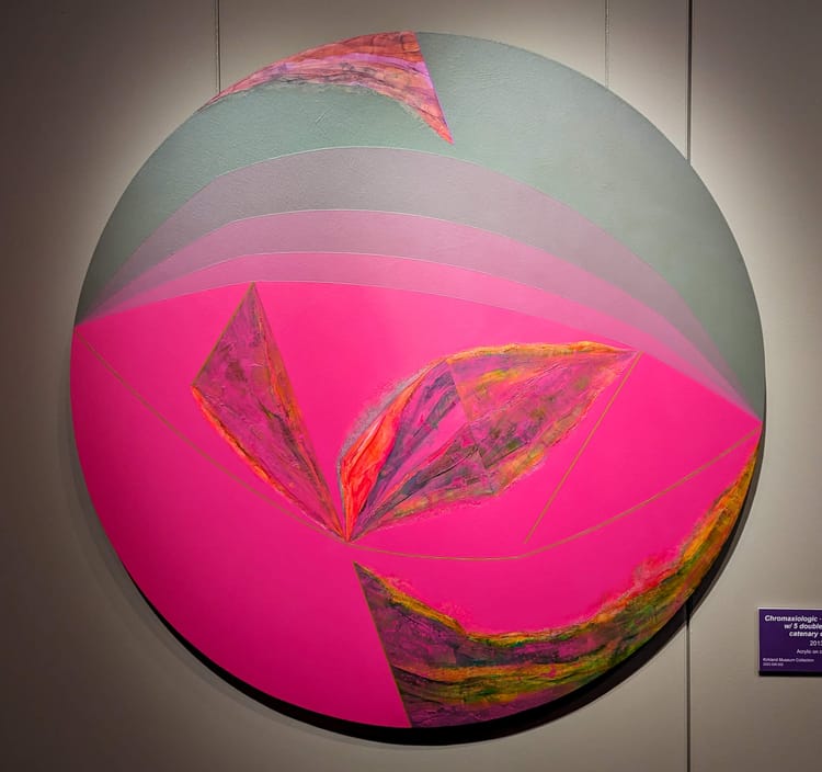 Circle artwork with graduated lines and a patch of vibrant pink color