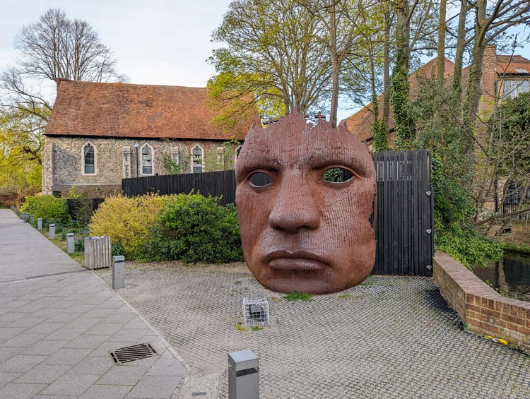 Large sculpture of a face, presented as a mask