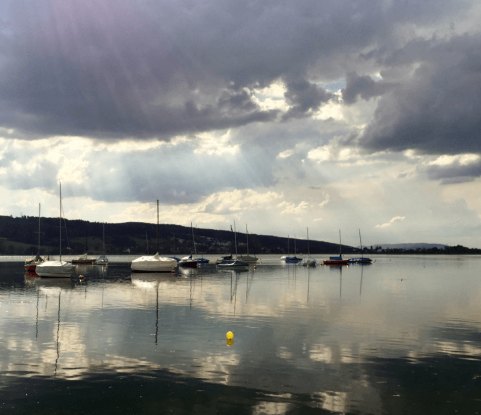 Slanting rays of sun over a smooth lake with sailboats - Moral Letters to Lucilius