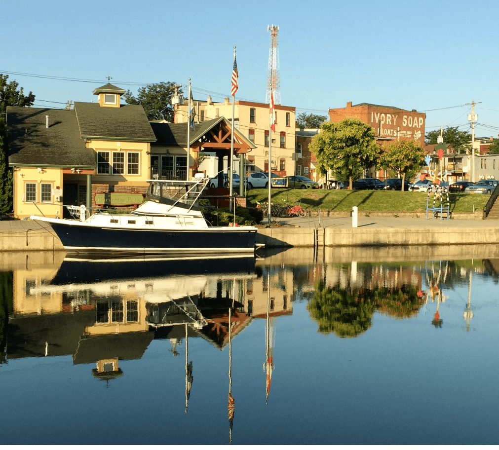 River with boat and buildings reflected in calm water - Moral Letters to Lucilius