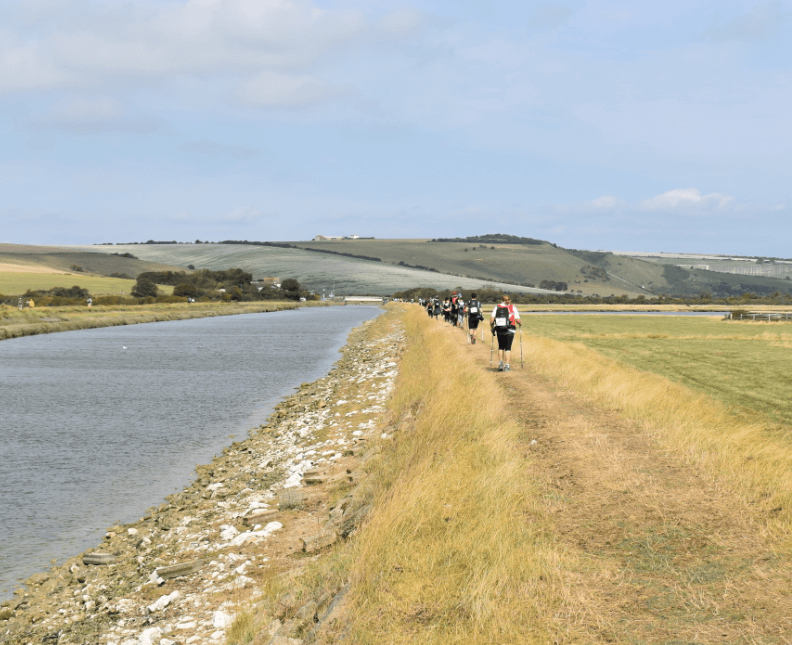 Trail with hikers walking alongside a river - Moral Letters to Lucilius