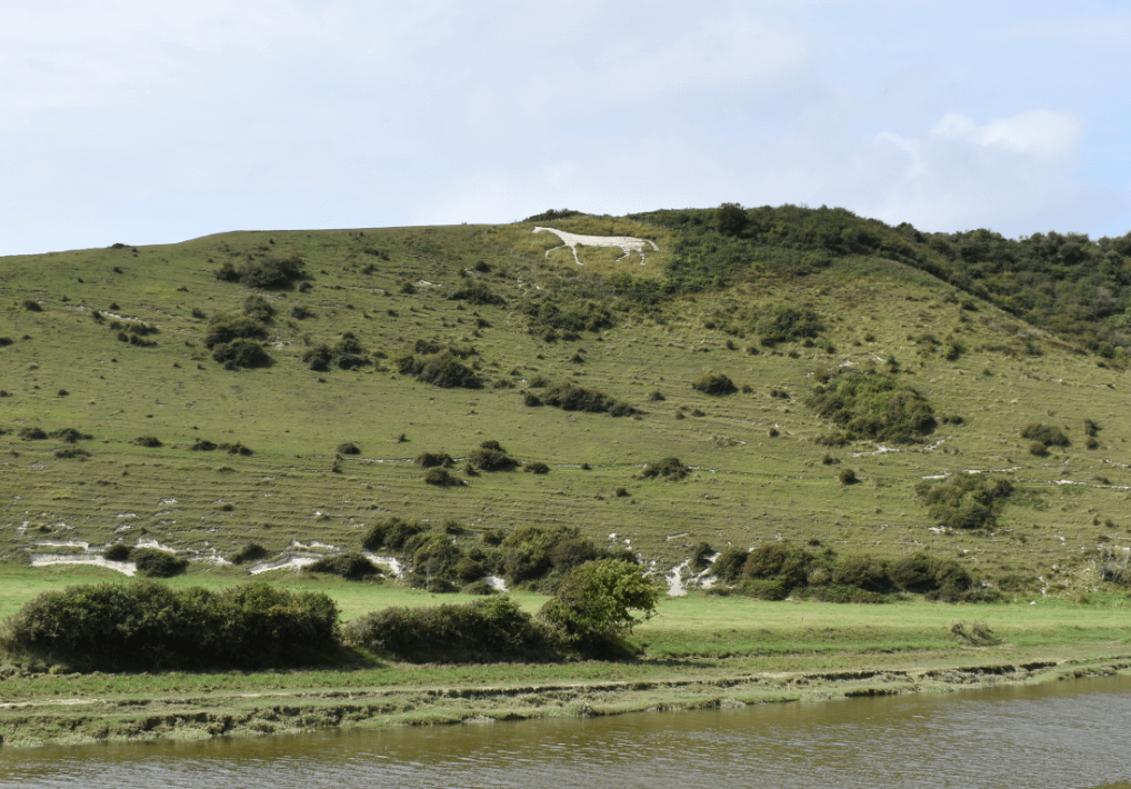 River in front of a hillside with a white horse carved into hill - Moral Letters to Lucilius