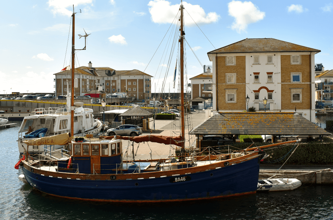 Sailboat in a harbor in front of apartment buildings - Moral Letters to Lucilius