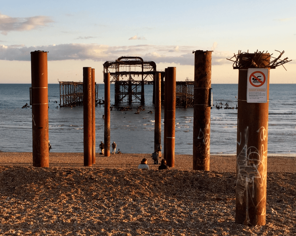 Rusty pier supports leading to a burnt out pier