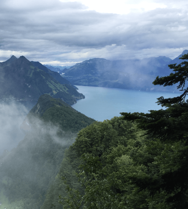 Light mist shrouding wooded mountains with a lake in the background