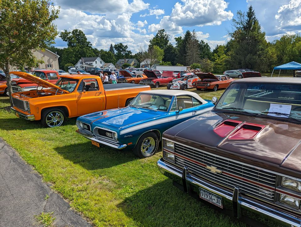 Colorful trucks and cars on green grass at a hobby car show