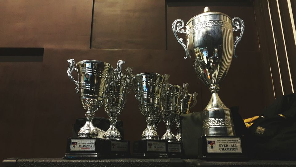Group of silver-colored trophies showing the champions