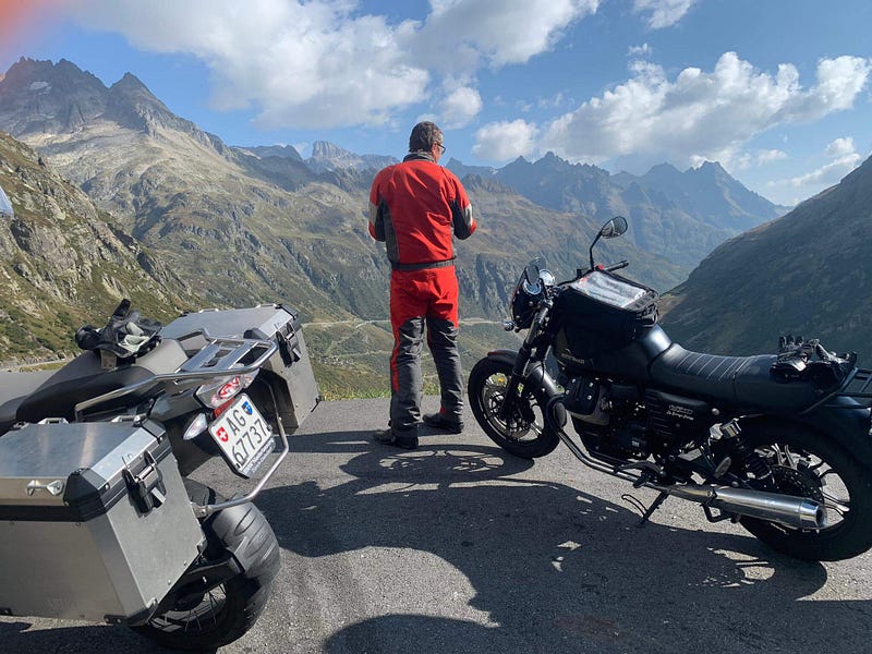 Resilience: a motorcyclist looking down over imposing mountain passes from above